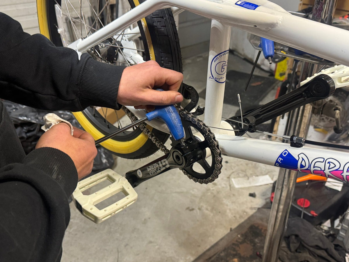 Mechanic tuning a BMX bike crankset at Doc's Bike Shop